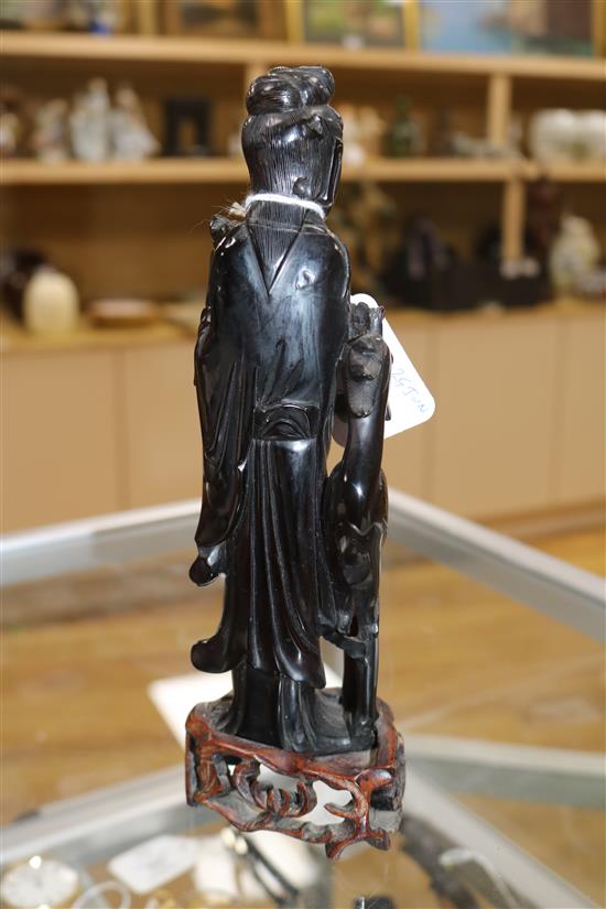 A Chinese faux amber standing figure of Xi Wangmu with a phoenix, wood stand, 23.5cm